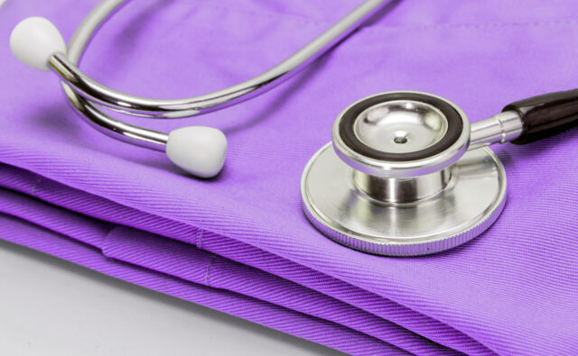 Stethoscope on clothes of nurse, conceptual image