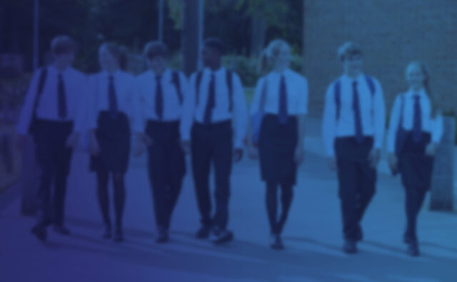 Group Of Teenage Students In Uniform Outside School Buildings