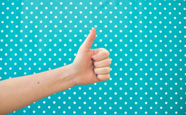 Thumbs up on bright polkadot background